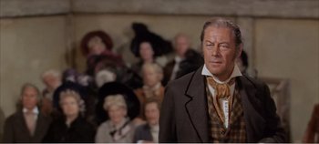 Movie still from “Doctor Dolittle” (1967), directed by Richard Fleischer – A man in a suit standing in front of a group of people; Medium shot, Low angle