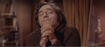 Movie still from “Doctor Dolittle” (1967), directed by Richard Fleischer – A man with long hair is praying with his eyes closed; Close Up shot, Low angle