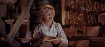Movie still from “Doctor Dolittle” (1967), directed by Richard Fleischer – A young boy sitting in a chair holding a piece of paper; Close Up shot, Low angle