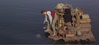 Movie still from “Doctor Dolittle” (1967), directed by Richard Fleischer – A man standing on a raft in the middle of a lake; Wide shot, High angle