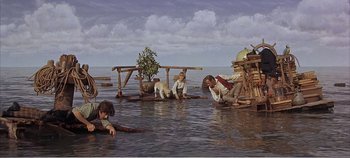 Movie still from “Doctor Dolittle” (1967), directed by Richard Fleischer – A group of people sitting in the water near a body of water; Wide shot, High angle