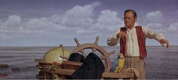 Movie still from “Doctor Dolittle” (1967), directed by Richard Fleischer – A man in a pirate costume standing next to a boat; Medium shot, Low angle