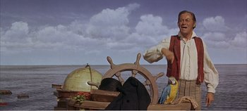 Movie still from “Doctor Dolittle” (1967), directed by Richard Fleischer – A man standing next to a steering wheel on a boat; Medium shot, Low angle