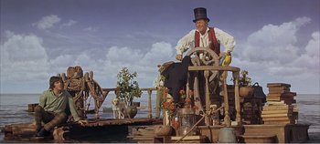 Movie still from “Doctor Dolittle” (1967), directed by Richard Fleischer – An old man wearing a top hat and holding a steering wheel; Wide shot, Low angle