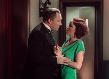 Movie still from “Doctor X” (1932), directed by Michael Curtiz – A man and a woman in a green dress; Medium shot, High angle