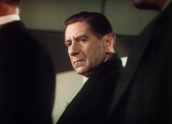 Movie still from “Doctor X” (1932), directed by Michael Curtiz – A person wearing a suit and tie; Close Up shot, Low angle