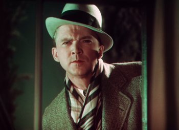 Movie still from “Doctor X” (1932), directed by Michael Curtiz – A man wearing a hat and a jacket; Close Up shot, Low angle