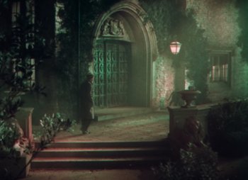 Movie still from “Doctor X” (1932), directed by Michael Curtiz – A man standing in front of an entrance to a building; Extreme Wide shot, High angle