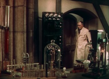 Movie still from “Doctor X” (1932), directed by Michael Curtiz – A man in a lab coat standing in front of a machine; Medium shot, High angle