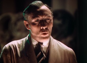 Movie still from “Doctor X” (1932), directed by Michael Curtiz – A person wearing a suit and tie; Close Up shot, Low angle
