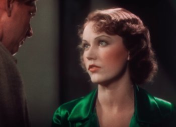 Movie still from “Doctor X” (1932), directed by Michael Curtiz – A woman in a green dress looking at a man in a green suit; Close Up shot, Over the shoulder angle