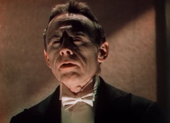 Movie still from “Doctor X” (1932), directed by Michael Curtiz – A person wearing a suit and bow tie; Close Up shot, Low angle