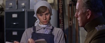 Movie still from “Doctor Zhivago” (1965), directed by David Lean – A woman wearing a head scarf and overalls looking down; Close Up shot, Low angle