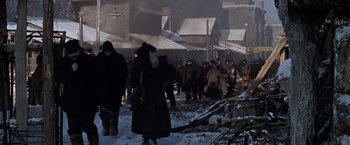 Movie still from “Doctor Zhivago” (1965), directed by David Lean – A group of people walking in the snow near buildings; Wide shot, High angle