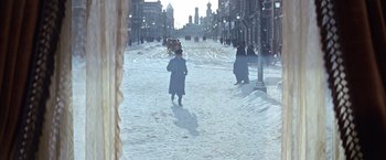 Movie still from “Doctor Zhivago” (1965), directed by David Lean – A man walking down a snowy street with a horse drawn carriage; Extreme Wide shot, High angle