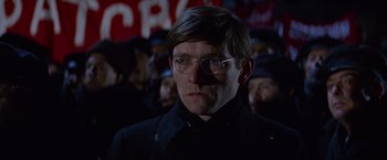 Movie still from “Doctor Zhivago” (1965), directed by David Lean – A man in a crowd of people wearing glasses and a black jacket; Close Up shot, Low angle