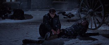 Movie still from “Doctor Zhivago” (1965), directed by David Lean – A man kneeling down next to a dead body in the snow; Wide shot, High angle