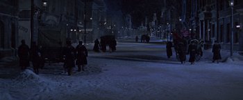 Movie still from “Doctor Zhivago” (1965), directed by David Lean – People are walking down a snowy street at night; Extreme Wide shot, High angle