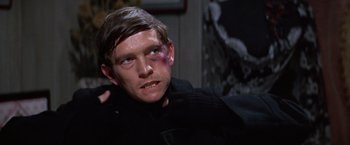 Movie still from “Doctor Zhivago” (1965), directed by David Lean – A man with a black shirt on and a black eye; Close Up shot, Over the shoulder angle