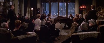 Movie still from “Doctor Zhivago” (1965), directed by David Lean – A group of people sitting in front of a grand piano; Wide shot, High angle