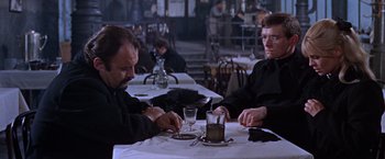 Movie still from “Doctor Zhivago” (1965), directed by David Lean – Two men sitting at a table in front of each other at a restaurant; Medium shot, Over the shoulder angle