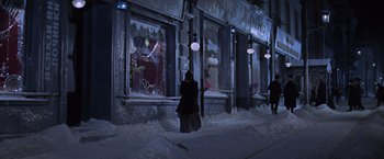 Movie still from “Doctor Zhivago” (1965), directed by David Lean – A person walking on the sidewalk in front of a store; Wide shot, High angle