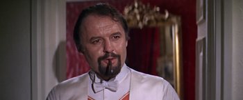 Movie still from “Doctor Zhivago” (1965), directed by David Lean – A person wearing a suit and bow tie smoking a cigarette; Close Up shot, Low angle