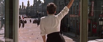Movie still from “Doctor Zhivago” (1965), directed by David Lean – A woman in white shirt and black skirt waving; Wide shot, Low angle