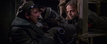 Movie still from “Doctor Zhivago” (1965), directed by David Lean – Two men are chained to each other in a dark room; Close Up shot, Over the shoulder angle