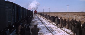 Movie still from “Doctor Zhivago” (1965), directed by David Lean – A group of people standing next to a train on a train track; Extreme Wide shot, High angle