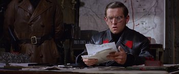 Movie still from “Doctor Zhivago” (1965), directed by David Lean – A man sitting at a table reading a piece of paper; Close Up shot, Low angle