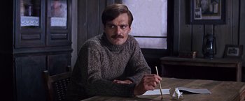 Movie still from “Doctor Zhivago” (1965), directed by David Lean – A man sitting at a table holding a pencil; Close Up shot, Over the shoulder angle