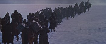 Movie still from “Doctor Zhivago” (1965), directed by David Lean – A group of people walking across a snow covered field; Wide shot, High angle