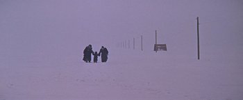 Movie still from “Doctor Zhivago” (1965), directed by David Lean – A group of people standing on a snow covered field; Wide shot, High angle