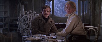 Movie still from “Doctor Zhivago” (1965), directed by David Lean – A man and a woman sitting at a table with plates of food; Medium shot, Low angle