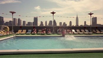 Movie still from “Dog Day Afternoon” (1975), directed by Sidney Lumet – People are swimming in a pool on the roof of a building; Extreme Wide shot, High angle
