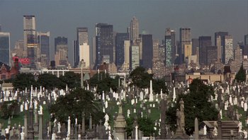 Movie still from “Dog Day Afternoon” (1975), directed by Sidney Lumet – A cemetery with a view of a city skyline; Extreme Wide shot, High angle