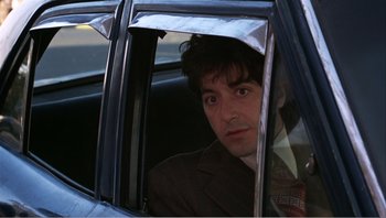 Movie still from “Dog Day Afternoon” (1975), directed by Sidney Lumet – A man sitting in the back seat of a car looking out the window; Close Up shot, Over the shoulder angle