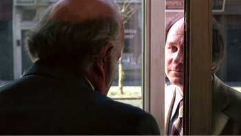 Movie still from “Dog Day Afternoon” (1975), directed by Sidney Lumet – An older man in a suit looking in a mirror; Medium shot, Over the shoulder angle