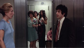 Movie still from “Dog Day Afternoon” (1975), directed by Sidney Lumet – A group of people standing in a room with a man; Medium shot, Low angle