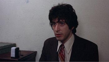Movie still from “Dog Day Afternoon” (1975), directed by Sidney Lumet – A man in a brown suit and a red tie; Close Up shot, High angle