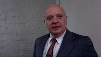 Movie still from “Dog Day Afternoon” (1975), directed by Sidney Lumet – An older man wearing a suit and tie; Close Up shot, Low angle