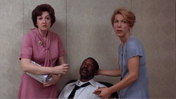 Movie still from “Dog Day Afternoon” (1975), directed by Sidney Lumet – Two women and a man in a room; Medium shot, High angle