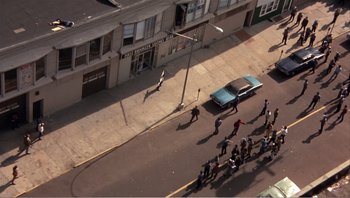 Movie still from “Dog Day Afternoon” (1975), directed by Sidney Lumet – A group of people walking down a street; Extreme Wide shot, High angle