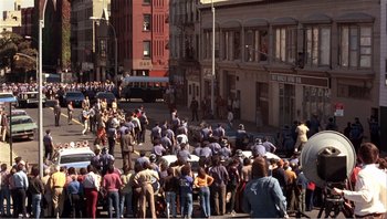 Movie still from “Dog Day Afternoon” (1975), directed by Sidney Lumet – A large group of people on a street; Extreme Wide shot, High angle
