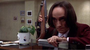 Movie still from “Dog Day Afternoon” (1975), directed by Sidney Lumet – A man with long hair holding a metal object in his hands; Close Up shot, Low angle