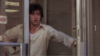 Movie still from “Dog Day Afternoon” (1975), directed by Sidney Lumet – A man in a white shirt is opening a door; Medium shot, Over the shoulder angle