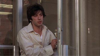 Movie still from “Dog Day Afternoon” (1975), directed by Sidney Lumet – A man in a white shirt is leaning against a window; Medium shot, Low angle