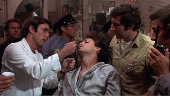 Movie still from “Dog Day Afternoon” (1975), directed by Sidney Lumet – A group of men standing in a room; Close Up shot, Low angle