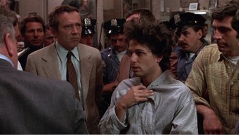 Movie still from “Dog Day Afternoon” (1975), directed by Sidney Lumet – A man that is standing in a crowd of people; Medium shot, Over the shoulder angle